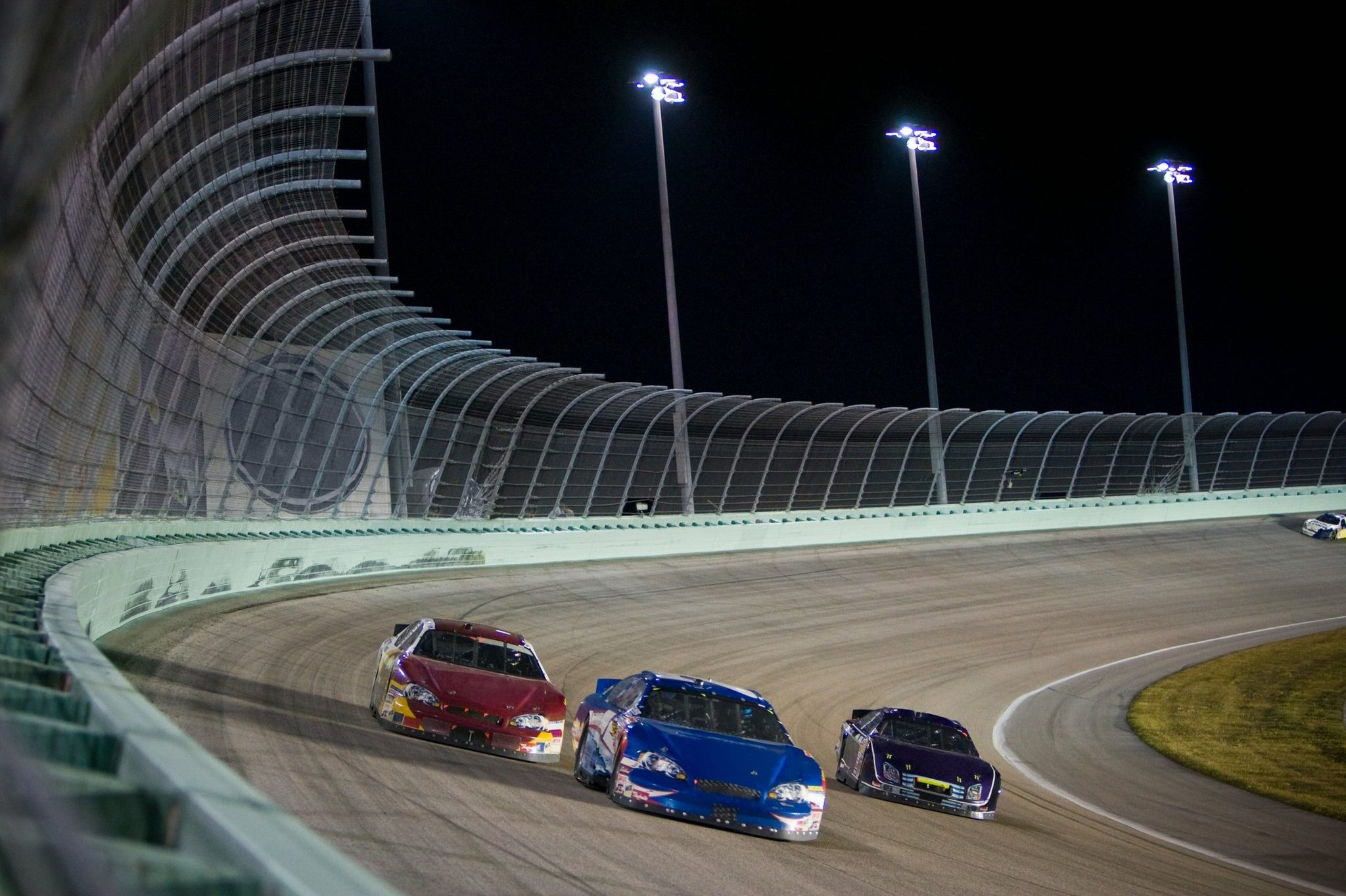 Racing cars on a floodlit track at night