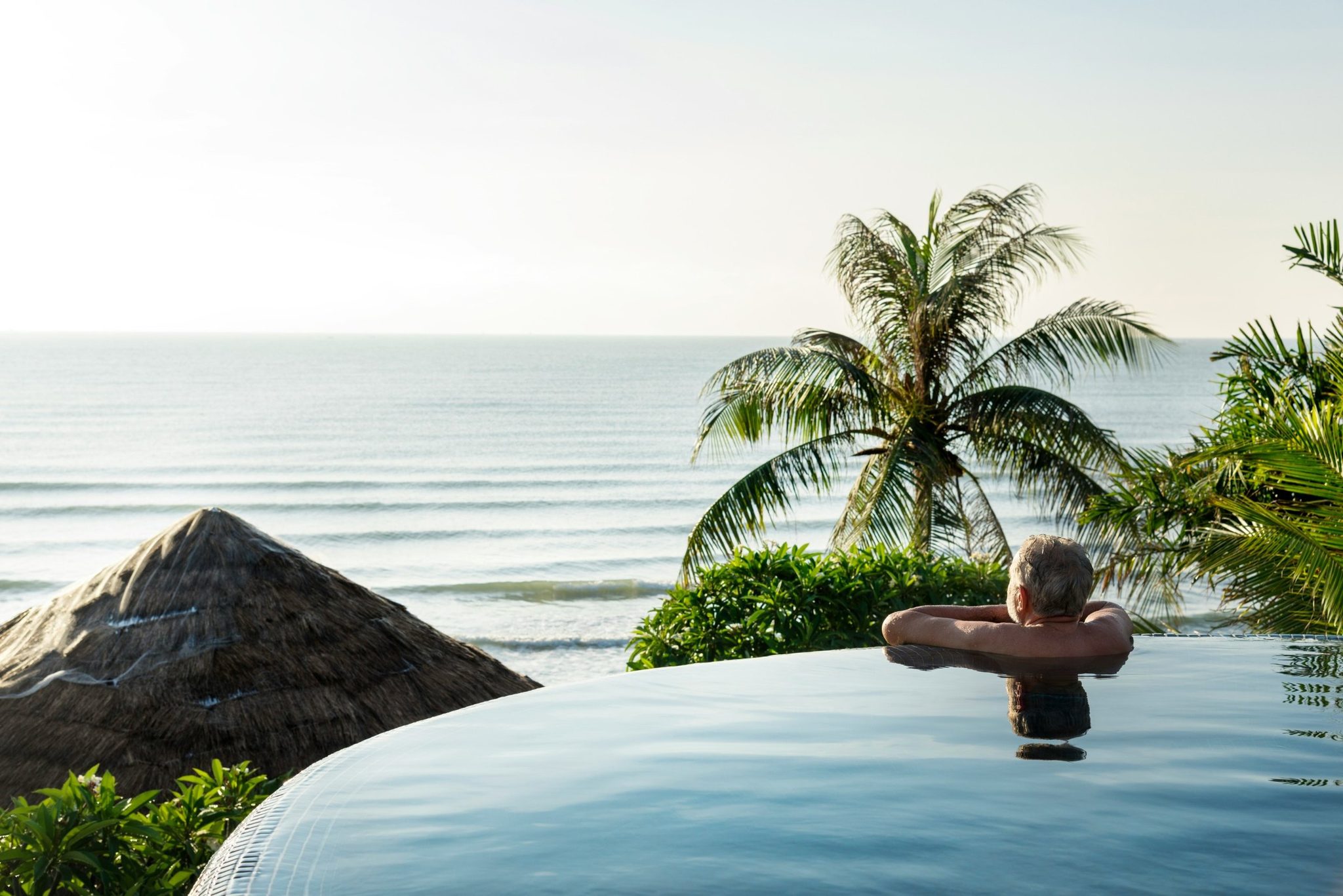 A guest in an infinity pool looking out to sea