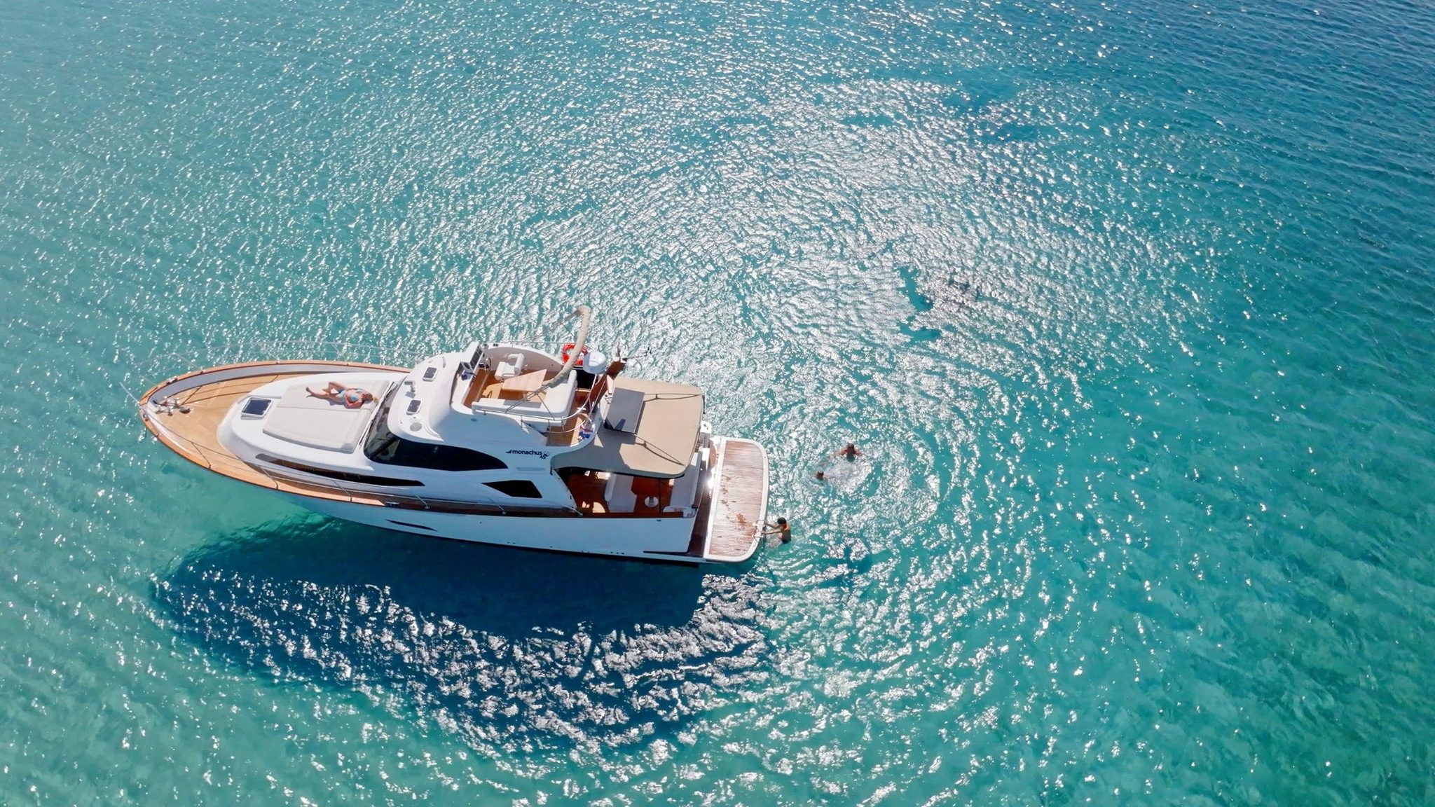 A yacht on turquoise water, seen from above